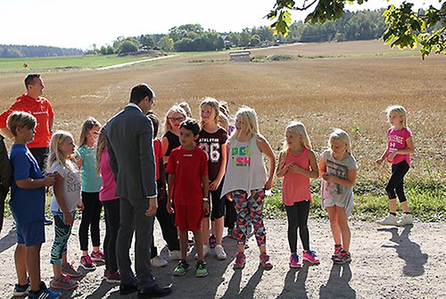 Prins Daniel talar med barnen i åk 3 som gör sig redo för dagens aktivitetspass – löpning. 