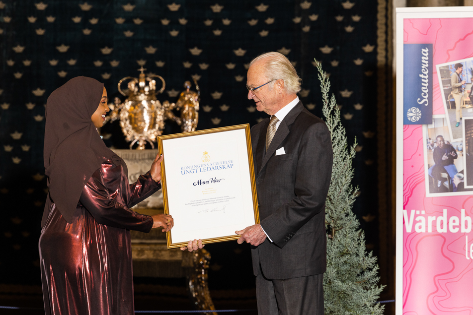 The King presents one of the 2021 scholarships to Muna Idow, founder of the Mermaid Swimming School in Gothenburg.