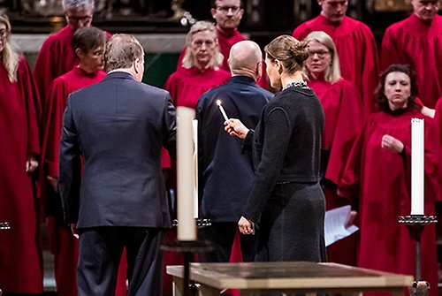 Kronprinsessan och statsministern tänder ljus vid minnesstunden i Storkyrkan. 